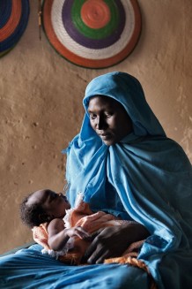 Maryam Mohammed, 24 years old, with her sixth newborn boy Abdalhaleem, 23 days old, delivered at home with the assistance of trained midwife Rabha Abdalraheem Ahmed. Marin village, Rahad locality, Gedaref Sate. Sudan 2015