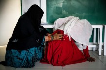 EMERGENCY's Maternity Centre, waiting room, 2019. Kuchi women: an elderly woman massages a young pregnant woman.
