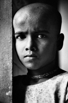 Lakshmi, 9 years, in the Bhajanashram. Vrindavan, India, 2004. Lakshmi bears the name of the goddess of wealth. Born blind, she is orphan of both her parents. She comes to sing every day in the Bhajanashram. Dressed in white, the color of renunciation and of mourning, shaved, she is a vegetarian and lives without shoes because “it is good to walk barefoot on Krishna’s land”. She is one of Lord Krishna’s brides too.