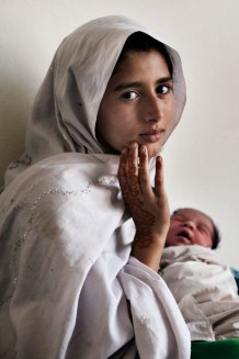 Nazi, 10 years old, with her newborn sister. Nowshera District, KPK, Pakistan, 2014.