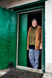Tetiana, 66, a widow, displaced person, and a beneficiary, during a home visit. Tetiana had three children, one of whom volunteered and died in 2024; his body was returned to her only two months later. One lived in Crimea and hasn't been seen or heard from since the Russian annexation in 2014. A third lives with her. They left all their possessions and moved with all their animals and plants. She mourns her dead son, but life goes on with her only remaining son and her granddaughter, she says. Blyzniuky, Kharkiv Region. Ukraine, 2026