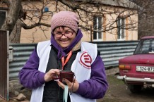 Tetiana, 54, a local community worker, stands outside her home, ready for house calls. She dreams only of the war ending, as it has brought physical, mental, and financial problems. She is very satisfied with her profession. Dmytrivka, Kharkiv Region, Ukraine, 2026